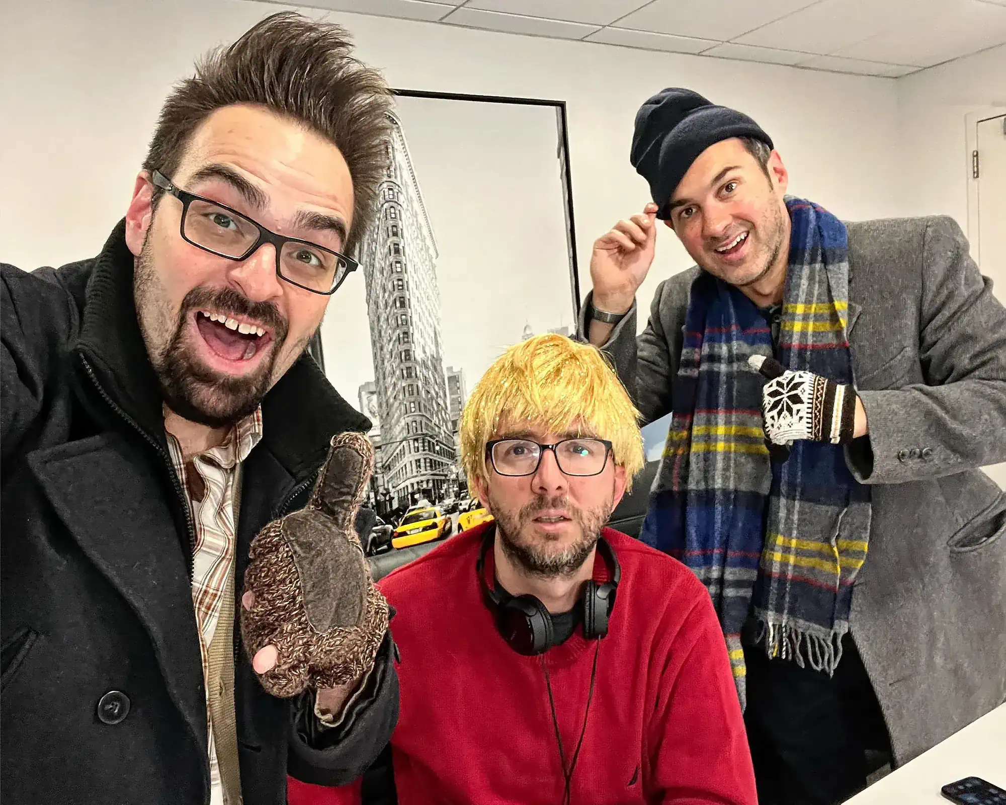 Comedians Mark Normand and Joe List of Tuesdays with Stories with producer Chuck Staton, taking a selfie, with Joe in a wig. Find Mark Normand Tour Dates and Joe List Tour Dates at www.tuesdayspod.com/find-a-show