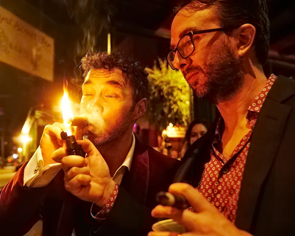Comedians Mark Normand and Joe List of Tuesdays with Stories lighting a cigar at Mark's wedding to Mae Planert in New Orleans. Find Mark Normand Tour Dates and Joe List Tour Dates at www.tuesdayspod.com/find-a-show