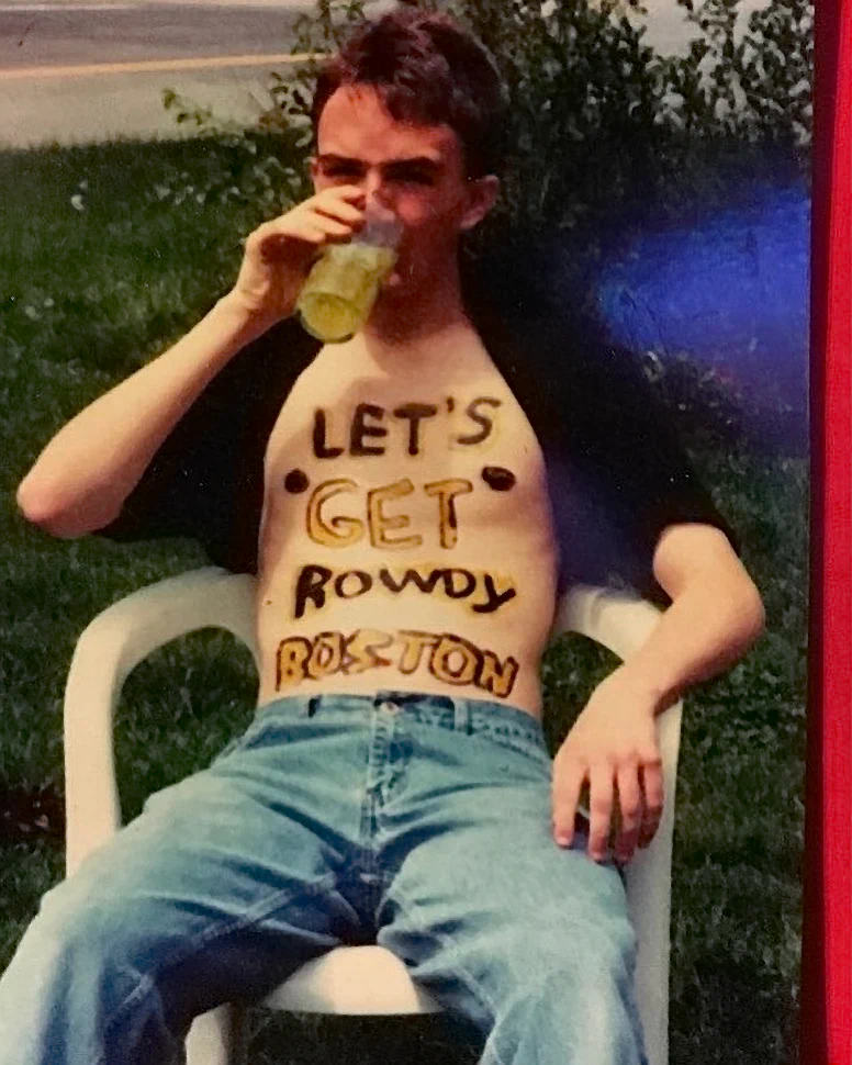 Comedian Joe List of Tuesdays with Stories drining a beer while shirtless with his chest painted. Find more about Joe at www.tuesdayspod.com/joe-list