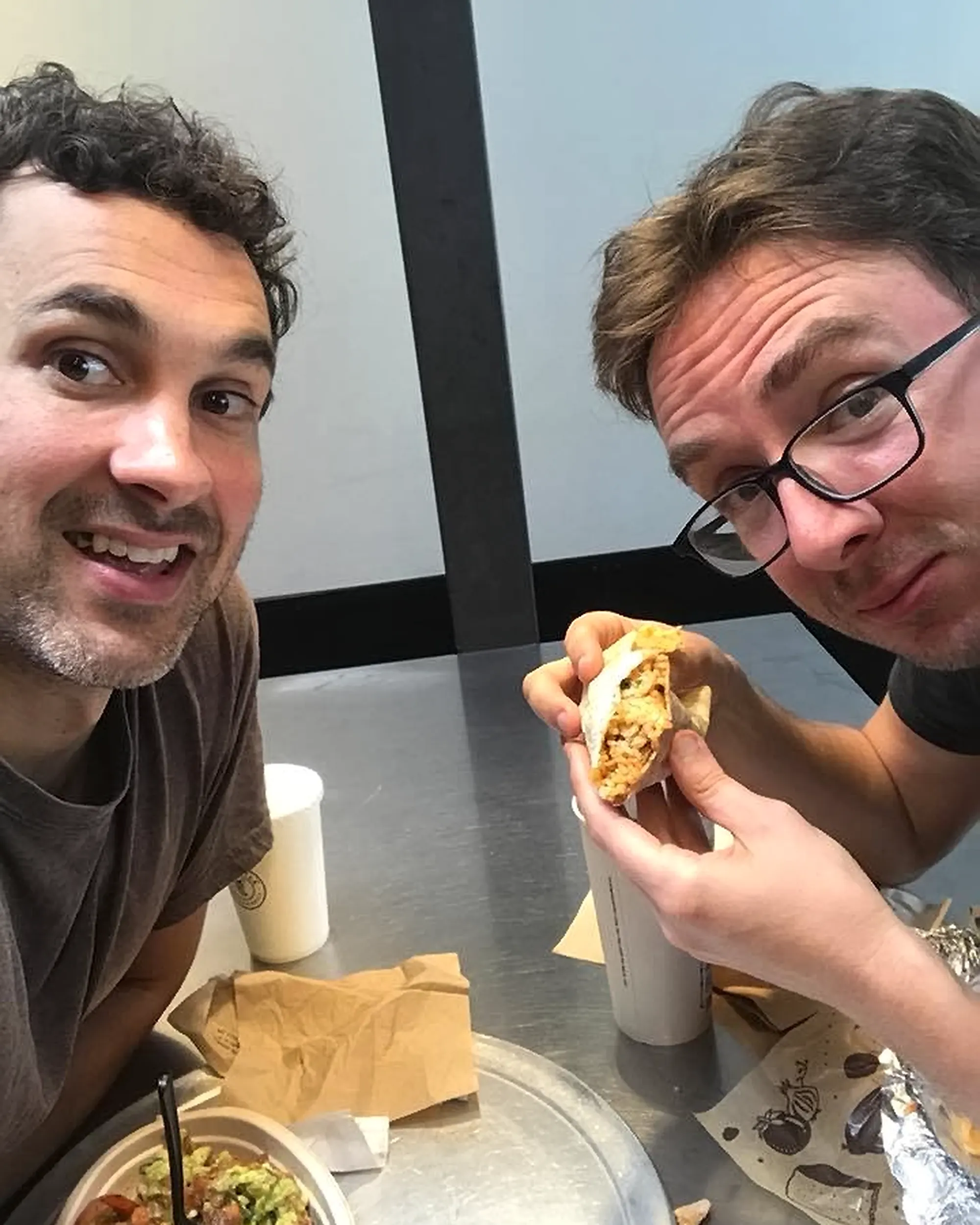 Comedians Mark Normand and Joe List of Tuesdays with Stories at Chipotle, eating burritos. Find Mark Normand Tour Dates and Joe List Tour Dates at www.tuesdayspod.com/find-a-show