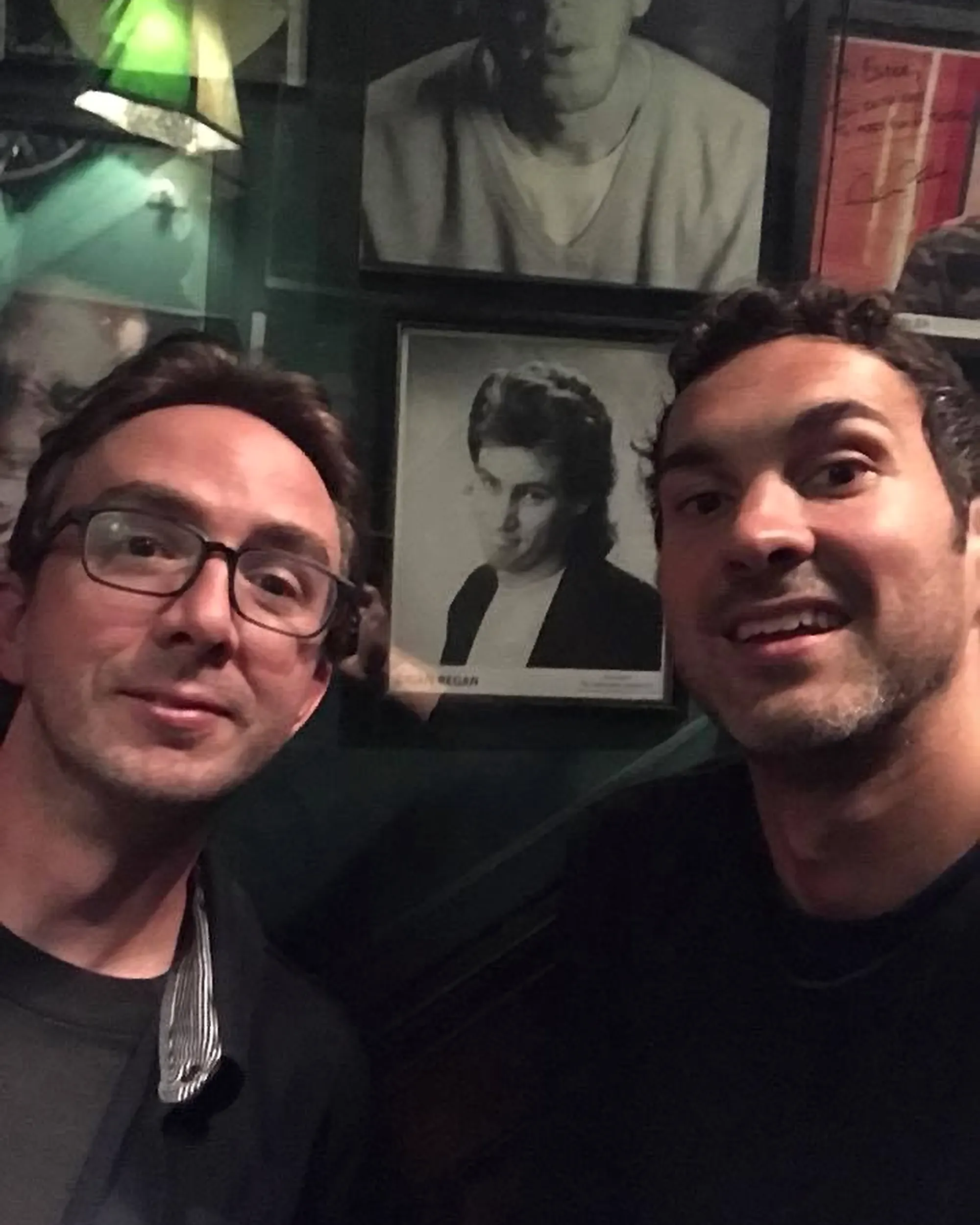 Comedians Mark Normand and Joe List of Tuesdays with Stories taking a selfie with a portrait of comedian Brian Regan of when he was young. Find Mark Normand Tour Dates and Joe List Tour Dates at www.tuesdayspod.com/find-a-show