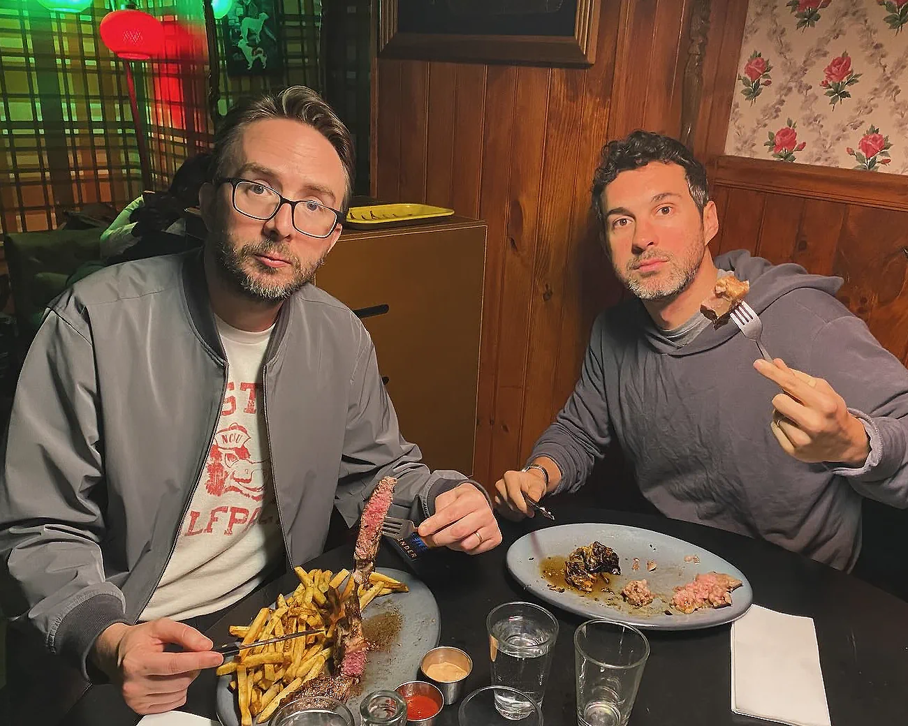 Comedians Mark Normand and Joe List of Tuesdays with Stories eating steaks and fries. Find more Tuesdays with Stories photos at www.tuesdayspod.com/photos