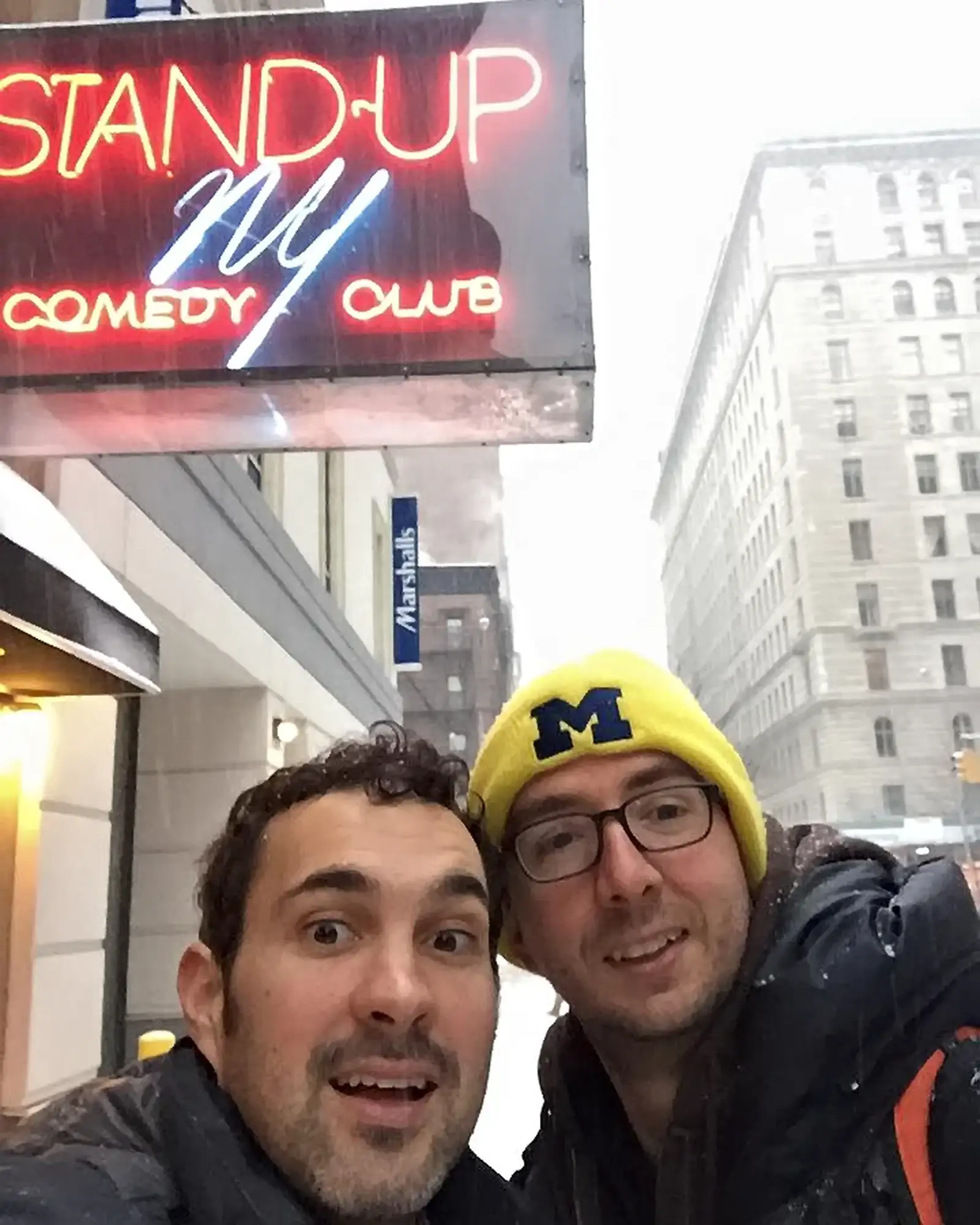 Comedians Mark Normand and Joe List of Tuesdays with Stories in front of Stand Up NY Comedy Club in New York in the Winter snow. Find Mark Normand Tour Dates and Joe List Tour Dates at www.tuesdayspod.com/find-a-show