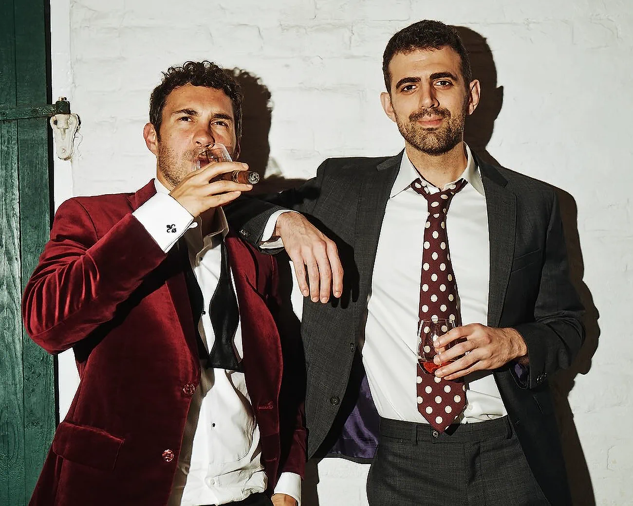 Comedian Sam Morril in a suit with Bodega Cat Whiskey and comedian Mark Normand of Tuesdays with Stories. Find more about Mark Normand at www.tuesdayspod.com/mark-normand